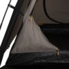 Close-up of a tan tent wall and zipper pulls inside the dark tent interior.